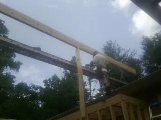 Carpenter setting a ridge beam over a new addition frame — Ice Dam Removal by Roofing Brothers in Janesville